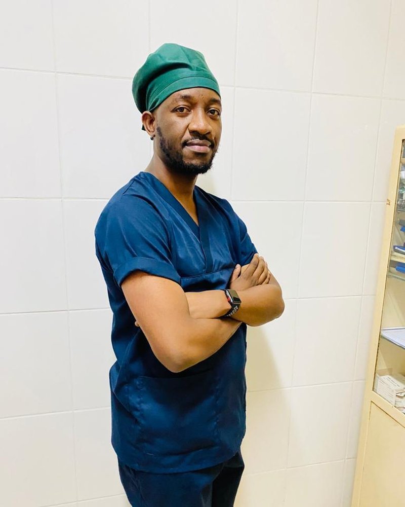 Dr. Juvenale pronto para uma cirurgia, de touca e farda azuis